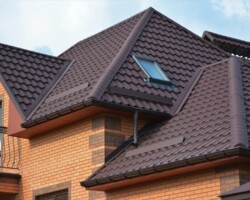 Dark tiled roof with roof window on a detached home